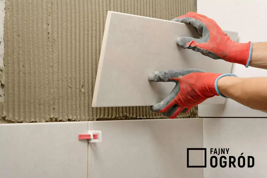 Fachowiec układa płytki na ścianie w łazience