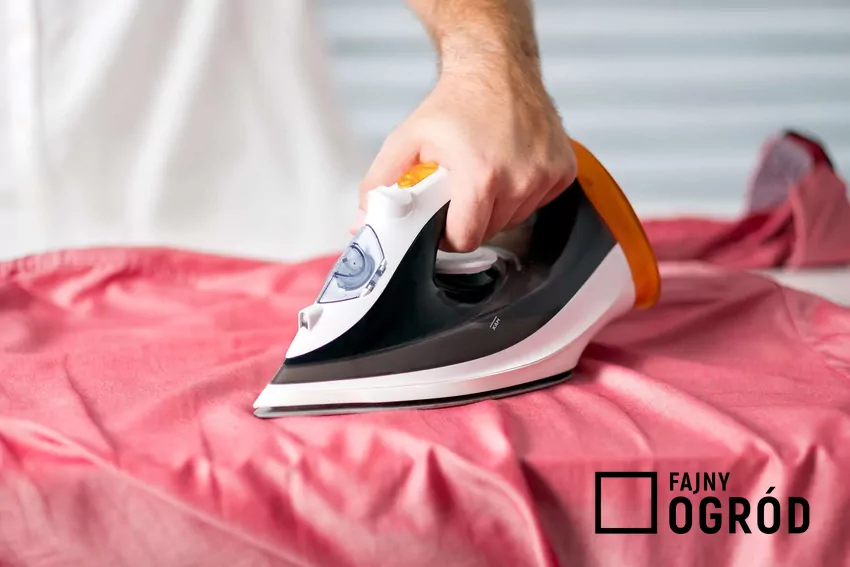 Mężczyzna prasujący koszulę żelazkiem