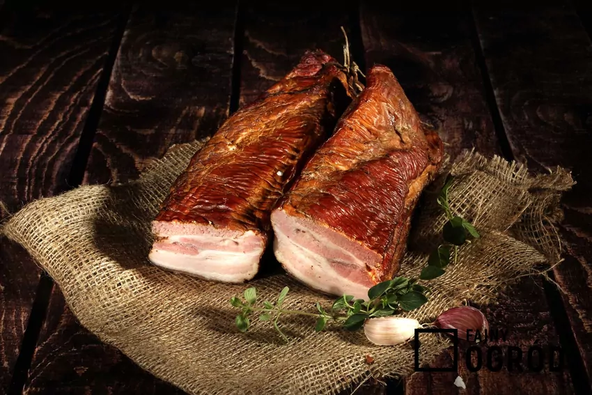 Wędzony boczek na drewnianym stole, a także przepisy, porady oraz najlepsze składniki i drewno do wędzenia