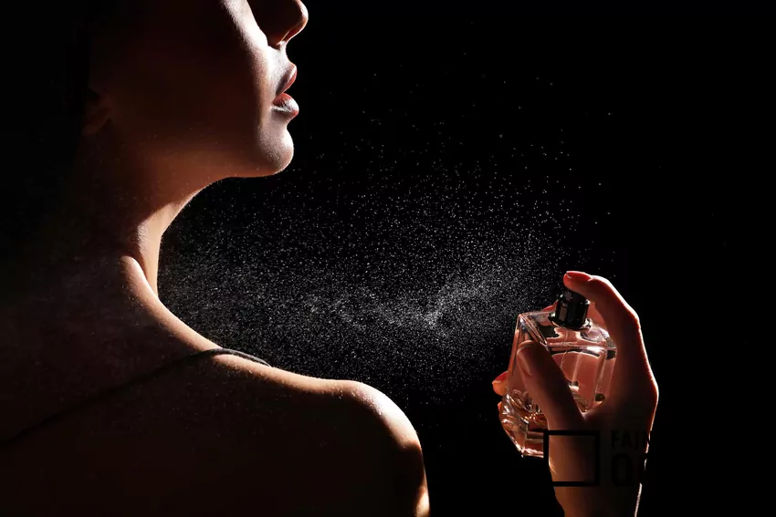 Kobieta pryska się perfumem