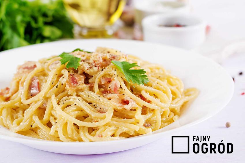 Spaghetti carbonara z boczkiem na białym talerzu, a także przepisy, składniki i przygotowanie